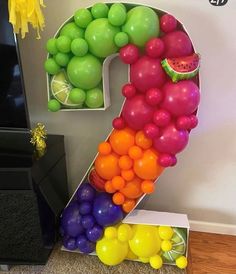 the number two is made out of balloons and watermelon, which are floating in the air