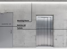 two metal doors are shown in front of a concrete wall with the words meeting room, necics ac toilets