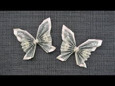 two butterflies made out of money sitting on top of a table