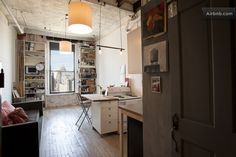 an open kitchen and living room area in a loft style apartment with wood flooring