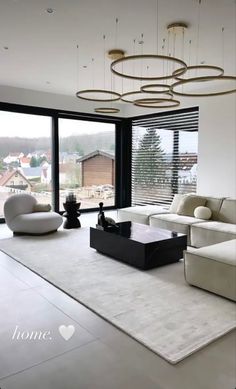 a living room with white furniture and large windows