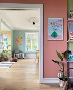 an open door leading to a living room filled with furniture and paintings on the walls