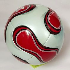 a red and white soccer ball sitting on top of a table