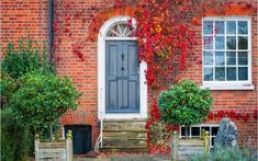 an old brick building with ivy growing on it's side door and steps leading up to the front door