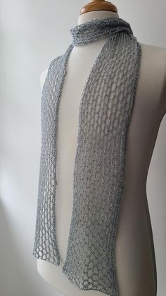 a white mannequin wearing a gray knitted scarf