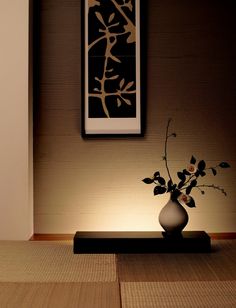 a vase filled with flowers sitting on top of a wooden table next to a painting