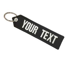 a black and white keychain with the words'your text'printed on it