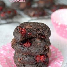 three chocolate cookies stacked on top of each other with cherries in the middle,