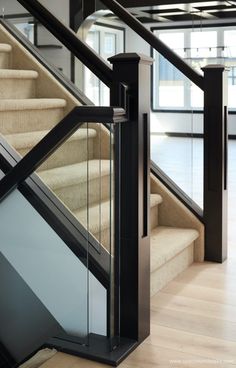 a stair case with glass railing and handrail