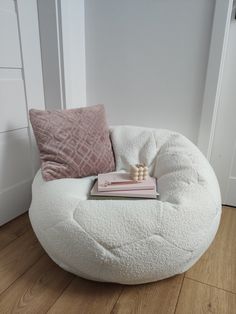 a white bean bag chair sitting on top of a hard wood floor