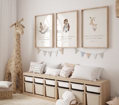 a room with three pictures on the wall and two stuffed giraffes in the corner