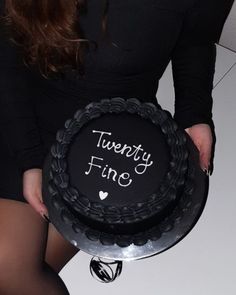 a woman holding a cake with the words twenty fine written on it and in front of her