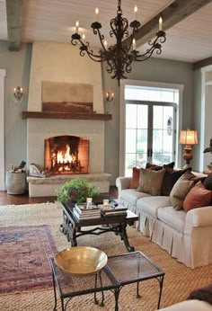 a living room filled with furniture and a fire place in the middle of the room