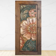 an art piece with flowers painted on it in a wooden frame next to a white wall