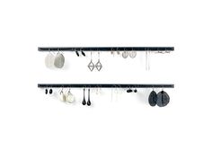 two black and white shelves with earrings hanging from them