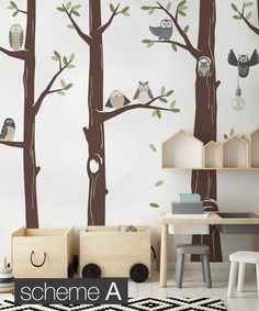 a child's room with wall decals that include owls on trees and birds hanging from the branches