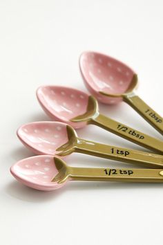 six pink and gold measuring spoons with white polka dots on them, labeled i love you