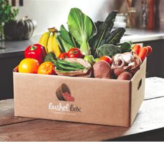 a box filled with lots of different types of vegetables on top of a wooden table