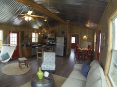 a living room filled with furniture next to a kitchen