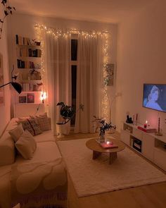 a living room filled with furniture and a flat screen tv on top of a wooden table