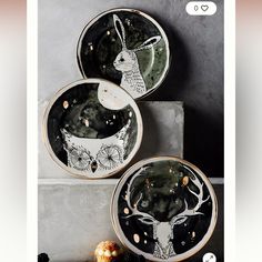 three black and white plates with deer designs on them, sitting next to each other