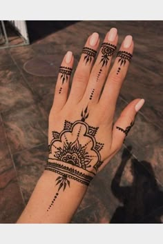 a woman's hand with henna tattoos on it