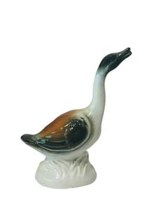 a ceramic bird sitting on top of a white base with an orange and black beak