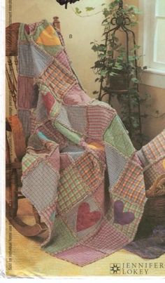 a quilted blanket sitting on top of a chair next to a potted plant