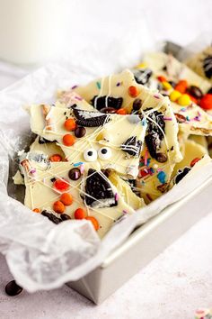 a white container filled with halloween treats on top of a table next to a glass of milk