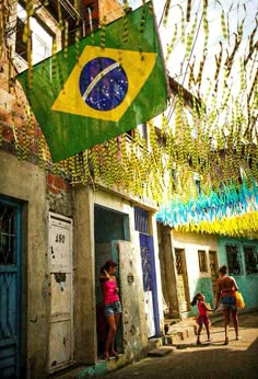 two people are standing in front of a building with a flag hanging from it