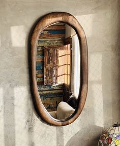 a mirror hanging on the side of a wall