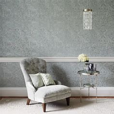 a chair and table in a room with wallpaper