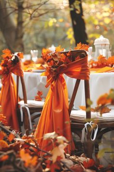 the chairs are covered with orange ribbons and bows for an elegant fall wedding table setting