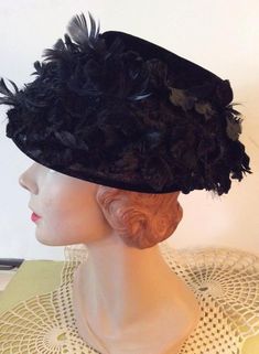 "Vintage 1950s Black Velvet Bucket style hat. Has a stiff lace base. Covered in Black Velvet petals and feathers. CONDITION: No issues noted. INSIDE CIRCUMFERENCE: 25\" This hat is a style that sits on the top of your head. You will see in the pictures (of the inside out of the hat) the part of the hat that will hold the hat in place. It will fit many head sizes. It even fits me! Height-6\" **WE APOLOGIZE~BUT WE CAN NO LONGER SHIP TO ITALY OR SPAIN. WE HAVE INCURRED TOO MANY ISSUES WITH SHIPPING Vintage Short Brim Mini Hat For Costume, Vintage Mini Hat With Short Brim For Costume, Vintage Short Brim Mini Hat For Costumes, Evening Costume Hat With Feathers, Vintage Brimmed Headpiece For Kentucky Derby, Vintage Brimmed Costume Hats For Party, Vintage Mini Hats With Curved Brim For Costume, Vintage Wide Brim Costume Hat For Evening, Vintage Costume Hats And Headpieces For Carnival