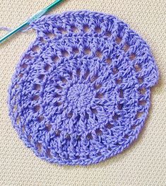 a crochet doily with a knitting needle next to it