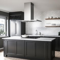 a kitchen with black cabinets and white subway backsplash