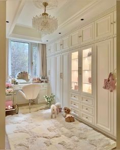 two dogs are sitting on the floor in front of an open cabinet and desk with a chandelier