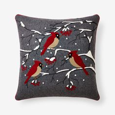 two red birds are sitting on the branch of a tree with snowflakes and berries