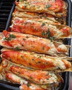 cooked lobsters on a grill with herbs and seasoning sprinkled on them