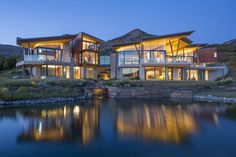 a large house sitting on top of a body of water next to a wooden dock