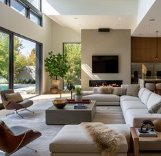 a living room filled with furniture and a fire place in the middle of an open floor plan