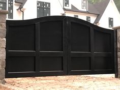 a large black gate in front of a house