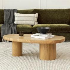 a coffee table sitting on top of a carpeted floor next to a green couch