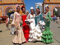 four women in dresses are posing for the camera