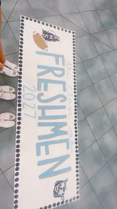 two people standing in front of a sign that reads figurine on the floor