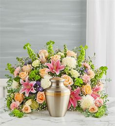 a vase filled with lots of flowers on top of a white marble counter next to a window