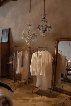 an old fashion store with clothes on racks and chandeliers