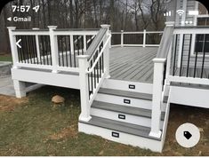 a deck with stairs and railings in front of a house