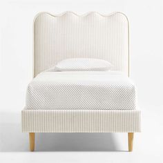 an upholstered white bed with wooden legs and headboard, made from fabric