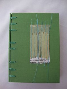 a green book with blue thread on it